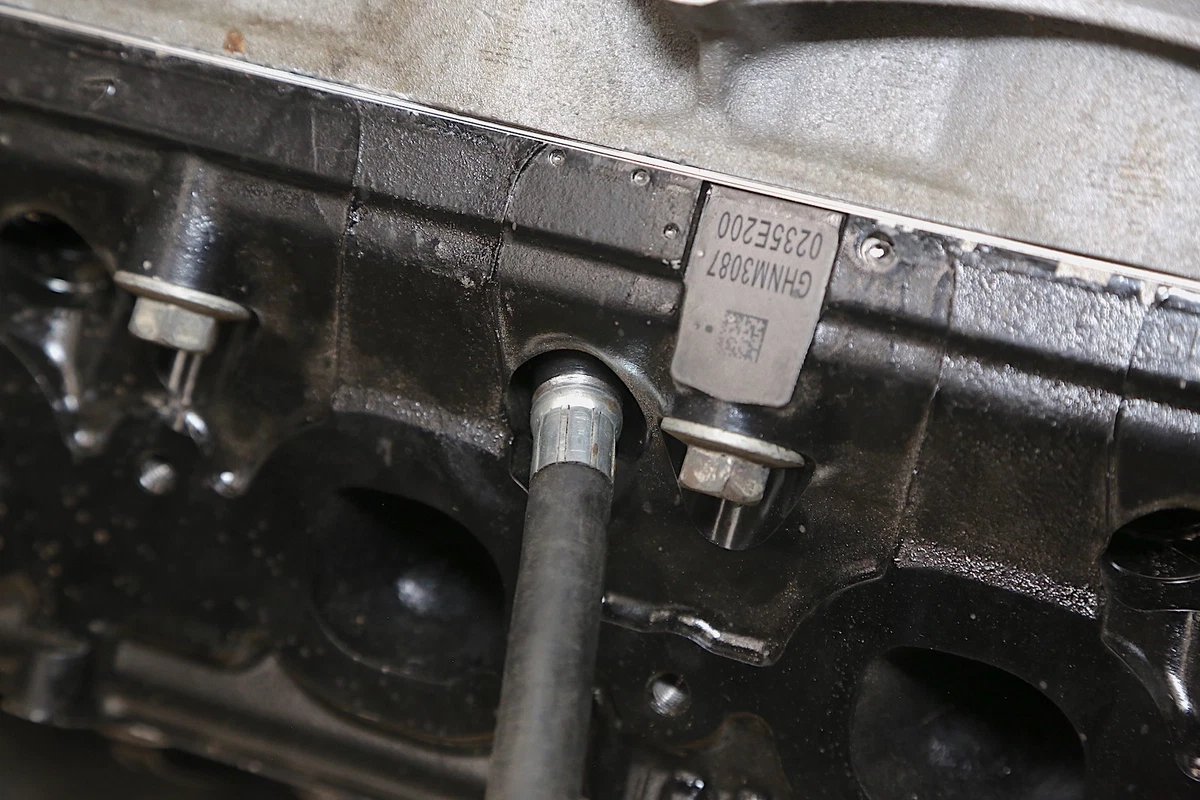 The engine compression test kit's adaptor threaded into the spark plug hole.