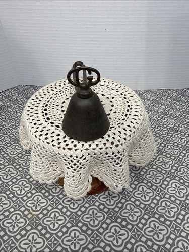 Antique silver Gilchrist Turnkey Type ice cream scoop with black metal bowl and white lace-patterned tablecloth.