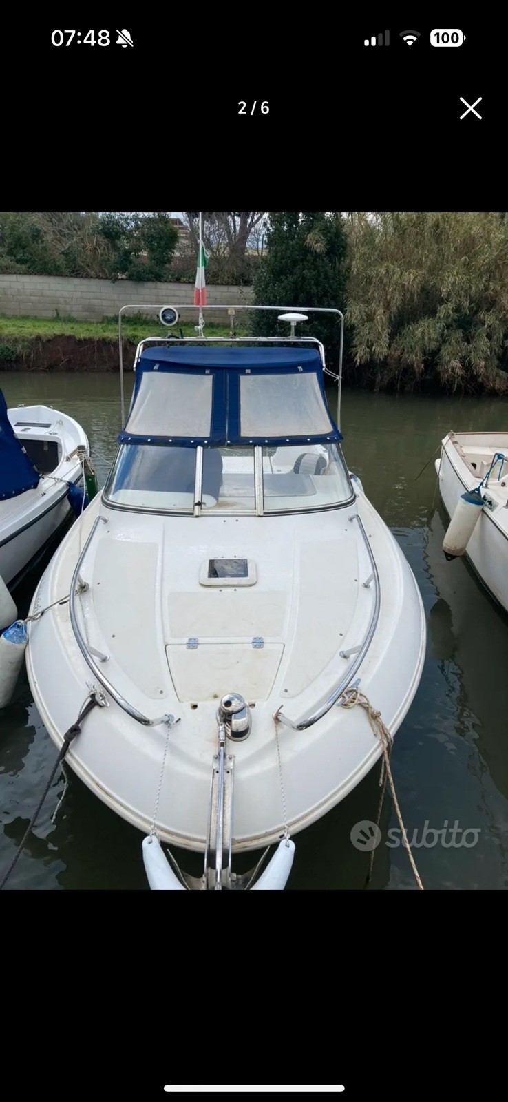 Barca a motore cabinata bianca con T-top, tendalino blu e tettuccio rigido