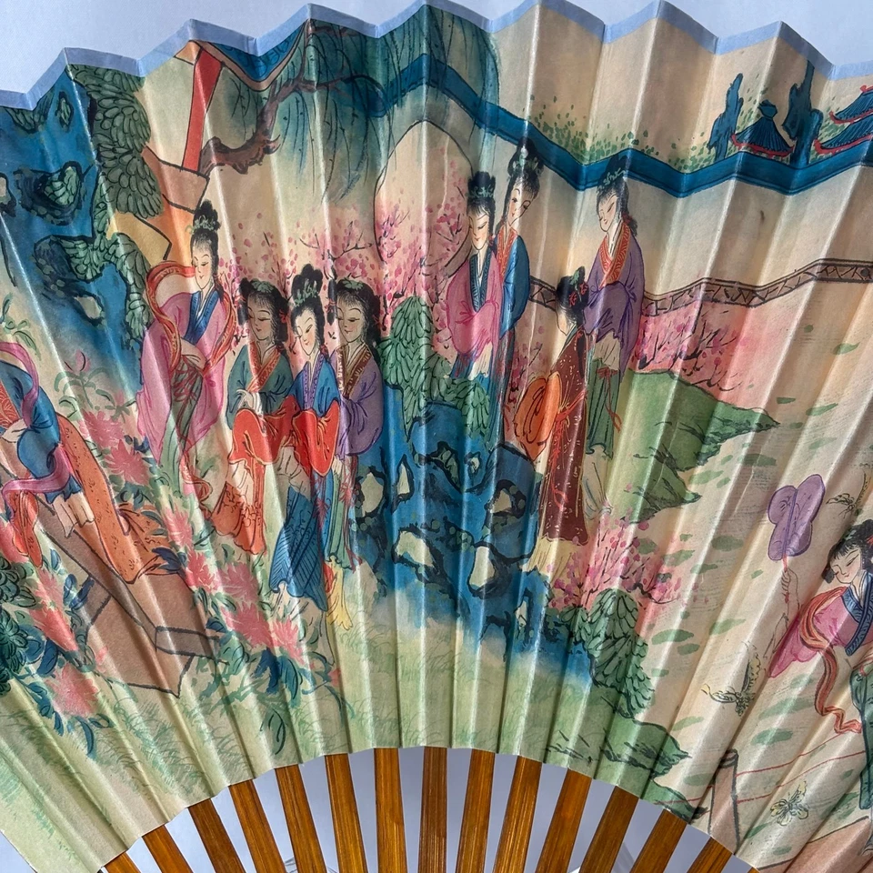Abanico plegable de papel oriental de colección para mujeres jóvenes en un jardín palos y protectores de bambú Foto 3 de 4