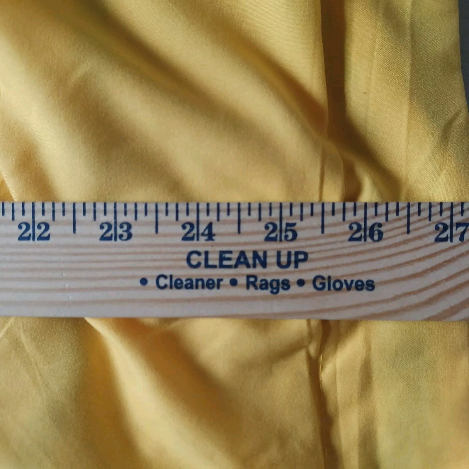 Yellow fabric pillow case with blue Northwest logo, white measurement markings in inches, and text “Clean Up • Cleaner Rags Gloves.”