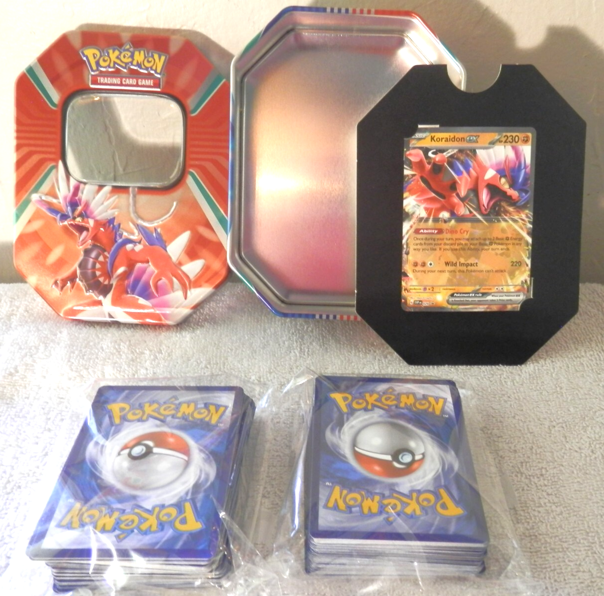 Orange Pokemon Trading Card Tin w/Shiny Koraidon EX Card and 100+ Cards Orange Pokemon Trading Card Tin w/Shiny Koraidon EX Card and 100+ Cards