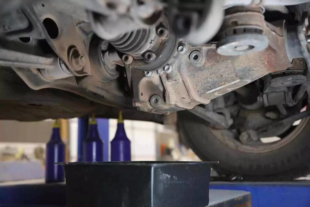 A black drain pan is placed beneath the rear differential of a vehicle.