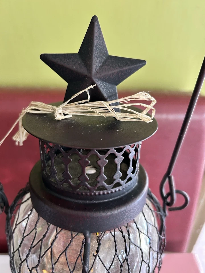 Linterna de patio iluminada de vidrio cerrado con alambre negro Foto 2 de 4