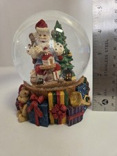 Santa Snow Globe stands 5 inches tall features Santa in his workshop