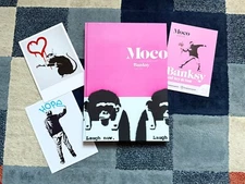Banksy Laugh Now MOCO Amsterdam Limited Edition Hardcover Book 2 Postcards NEW