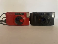 Two Canon Snappy 35MM Film Cameras Fully Automatic One Black One Red As Shown