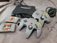 Nintendo 64 console with 2 controllers, AV cables, power cord, and 2 games