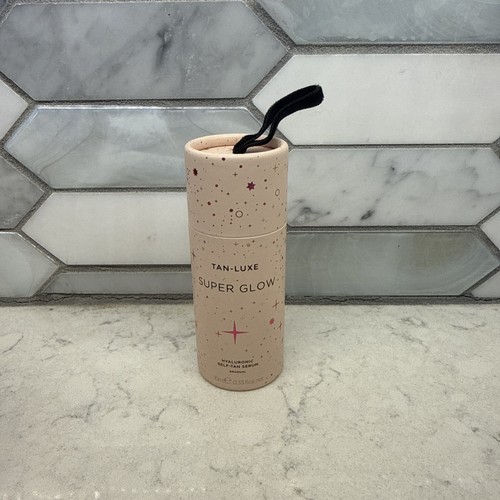 Tan-Luxe Super Glow Hyaluronic Self-Tan Serum Gradual in clear tube with black cap, BNIB, against white tile background.