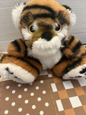 Pequeño cachorro de tigre bebé sentado con ojos que cambian de color de iridiscencia pies grandes peluche