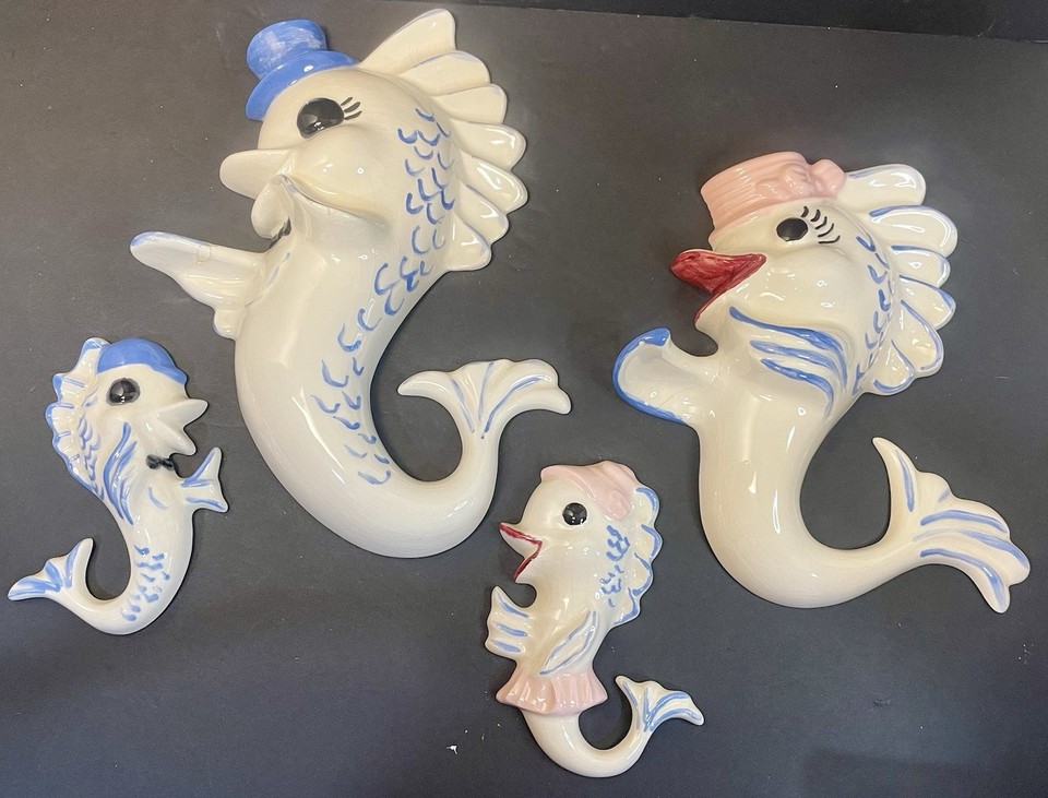 A set of four kitschy anthropomorphic fish family ceramic wall plaques — the kind of wonderfully weird mid-century décor that stops guests in their tracks and demands an explanation.