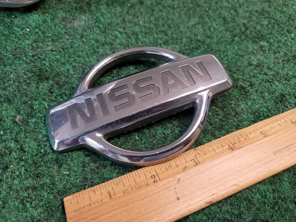 Nissan Pathfinder 1999 2000 2001 emblema de parrilla delantera 62890-2W300 OEM 2M4 Foto 2 de 4