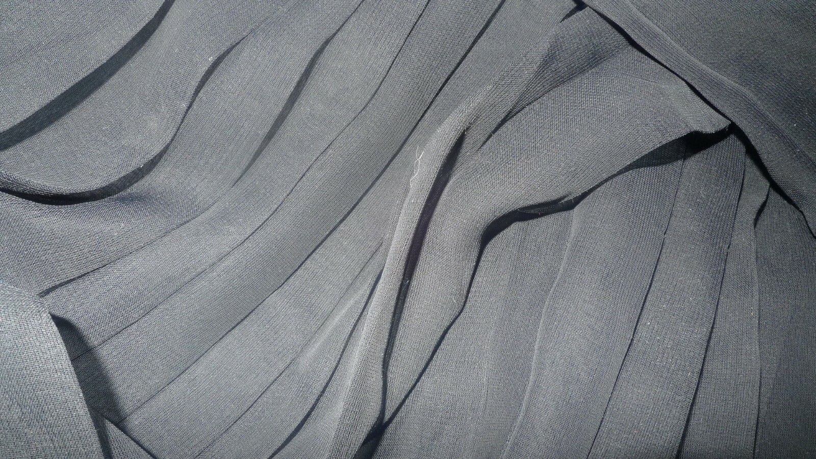 Tissu mousseline plissé noir en polyester pour confection de jupe élégante