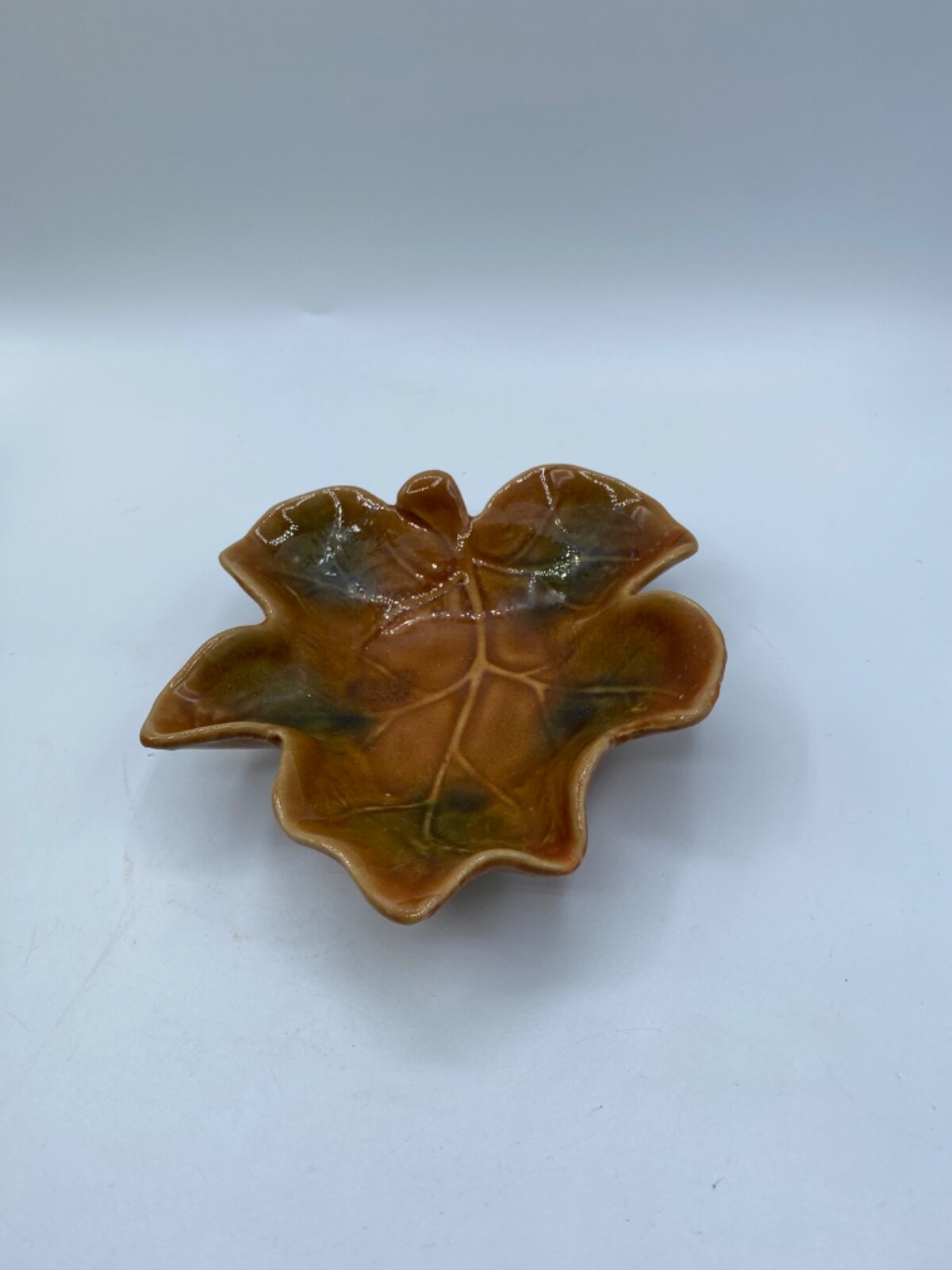 Small brown handmade majolica art pottery dish shaped like a leaf.