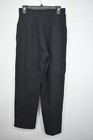 Black women's straight-leg pants with front pleats, side pockets, and belt loops, hanging on a black hanger.