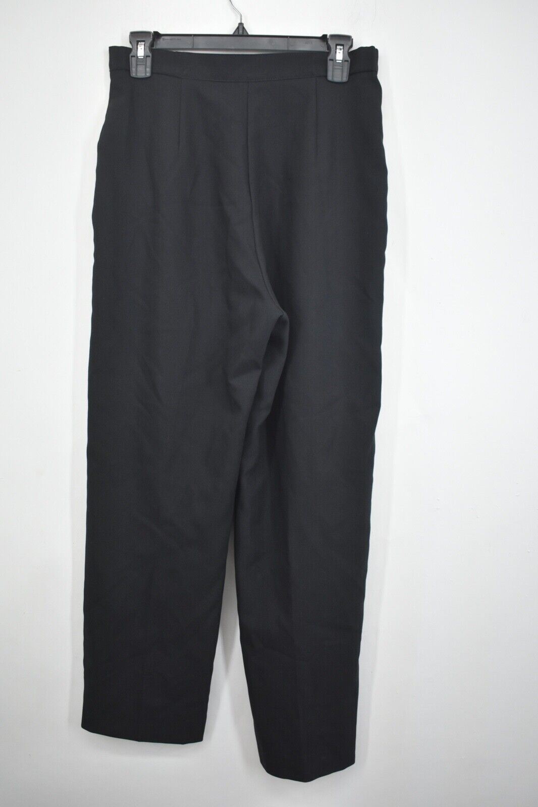 Black women's straight-leg pants with front pleats, side pockets, and belt loops, hanging on a black hanger.