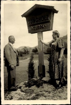 Photo postcard Jungholz in Tyrol, man and woman next to a town sign - 5019226