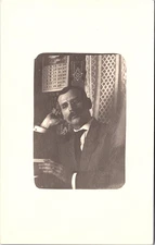 Man Reclined Reading Book Indoors with Patterned Wall, Oval RPPC Postcard