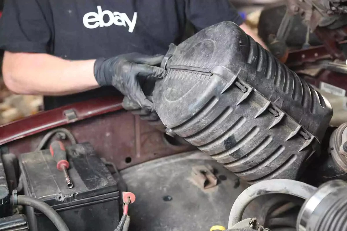 A mechanic removes components to gain access to the heater hoses.