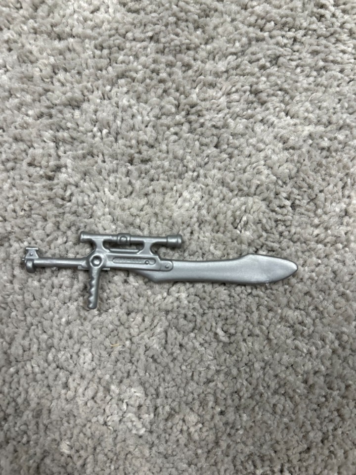 An original 1986 Masters of the Universe Eternia playset weapon part — a tiny piece of plastic that carries enormous 80s childhood power.