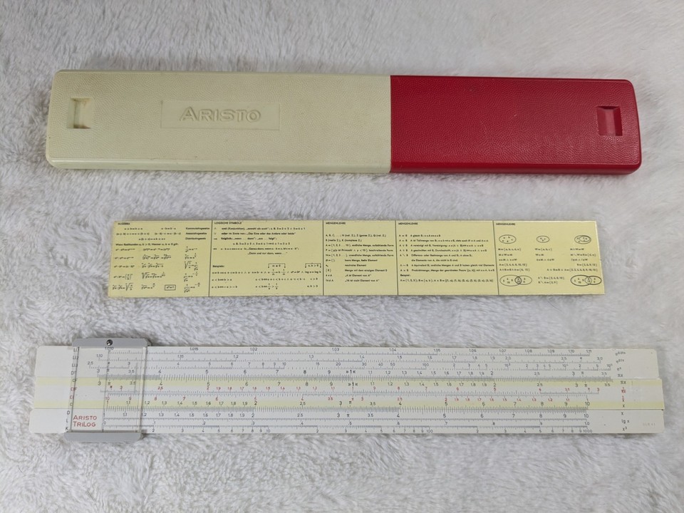 The Aristo TriLog was the go-to engineering slide rule in German universities — this one comes with its original German-language instruction insert, still intact.