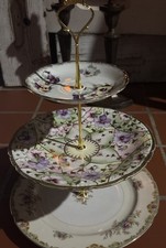 A three-tier porcelain cake stand with mismatched floral plates and gold trim.