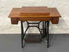 Antique treadle sewing machine in oak cabinet with cast iron base & accessories