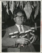 Press Photo  A man carrying many jars off canned goods - neo12938