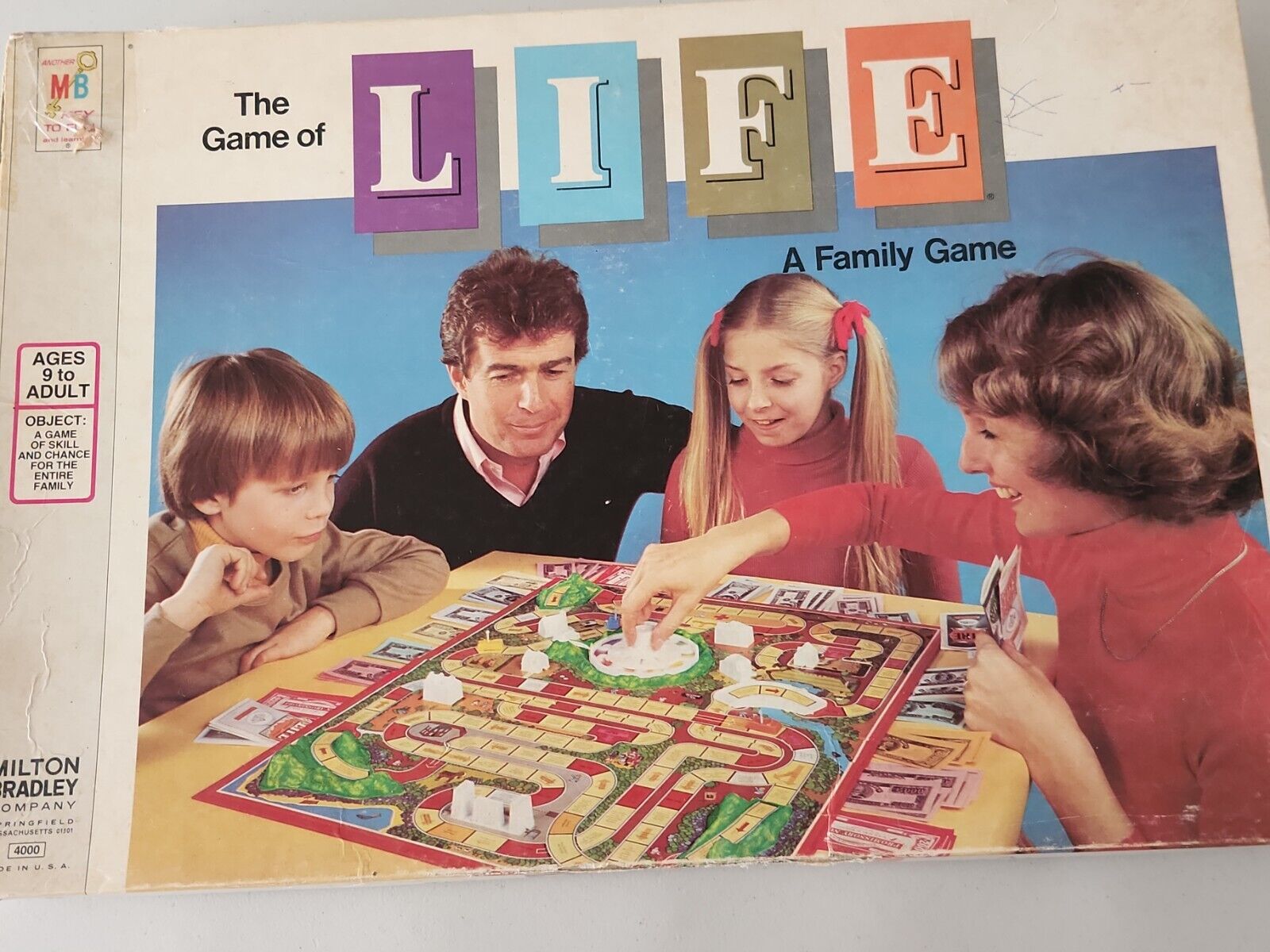 The Game of Life by Milton Bradley. The game board & all its