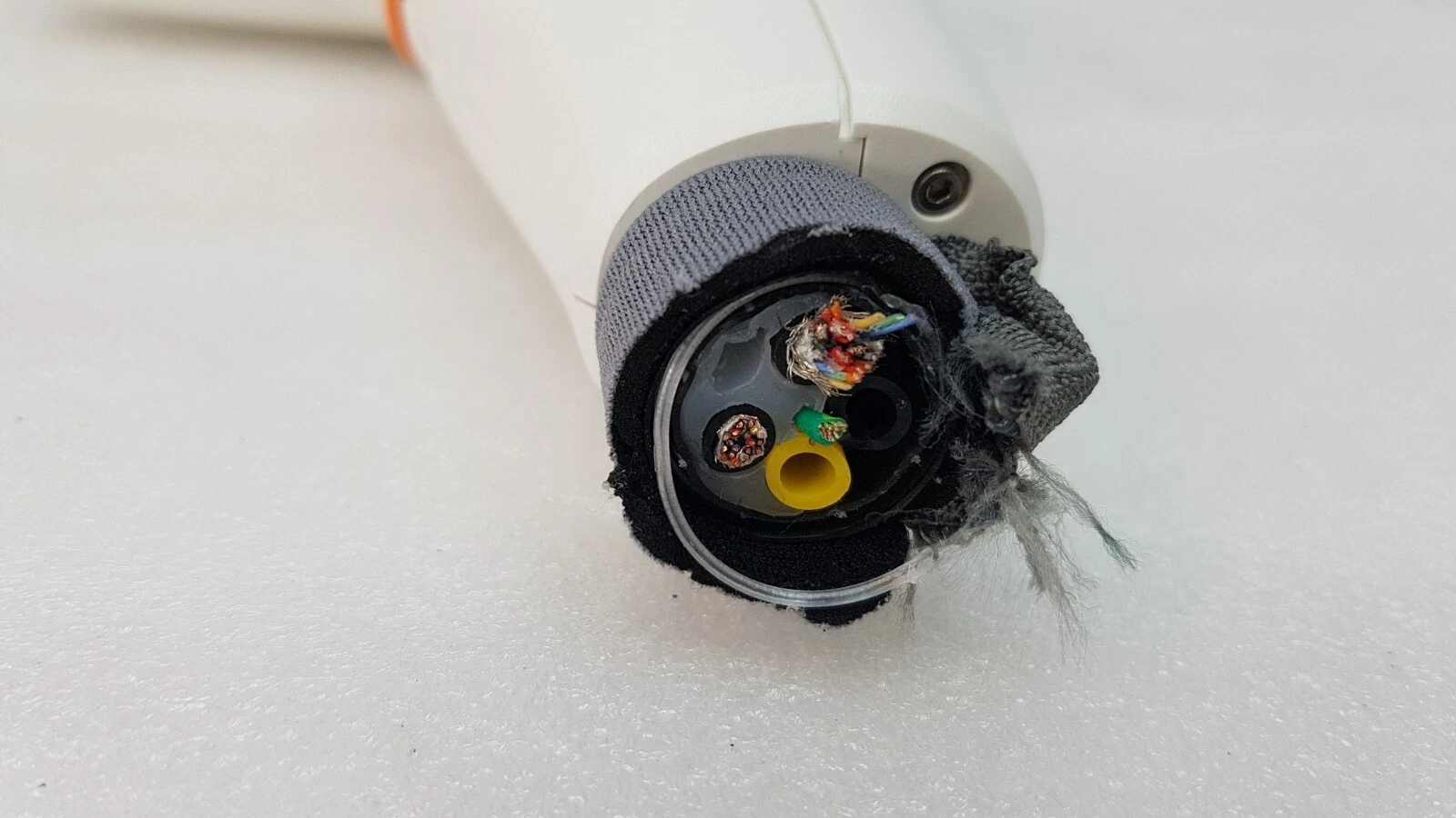 Cut cable at the base of the ResurFX handpiece grip showing wires and a yellow tube