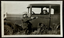 Rifle de apunta a niño pequeño por coche antiguo conducido por hermosa madre foto de colección