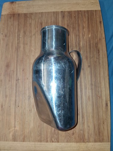 Antico orinatoio maschio in acciaio inox tenuto a mano senza marchio datato 1954