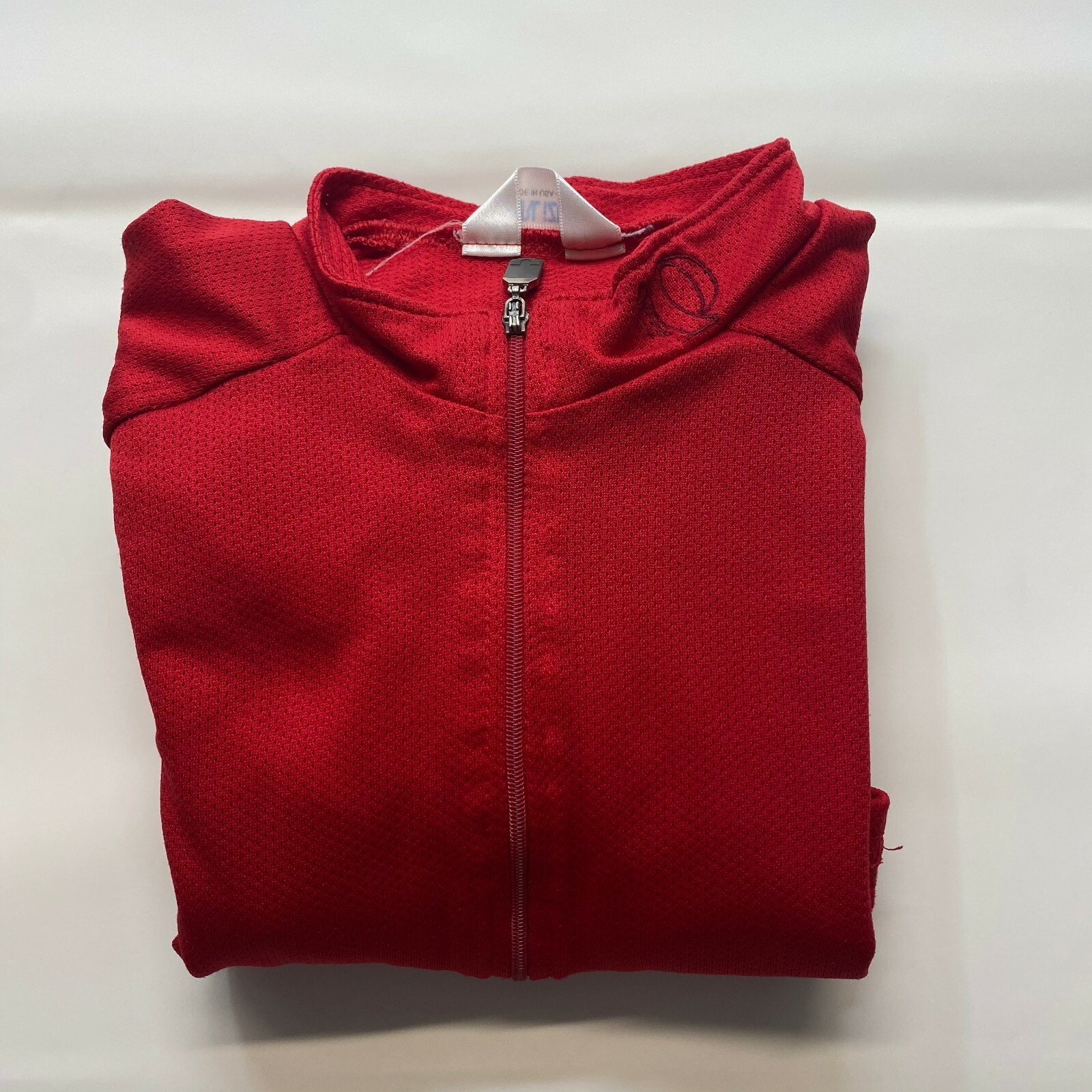 Red mesh Izumi men’s cycling shirt with half zip, made in USA, featuring small white Izumi logo on both shoulders.