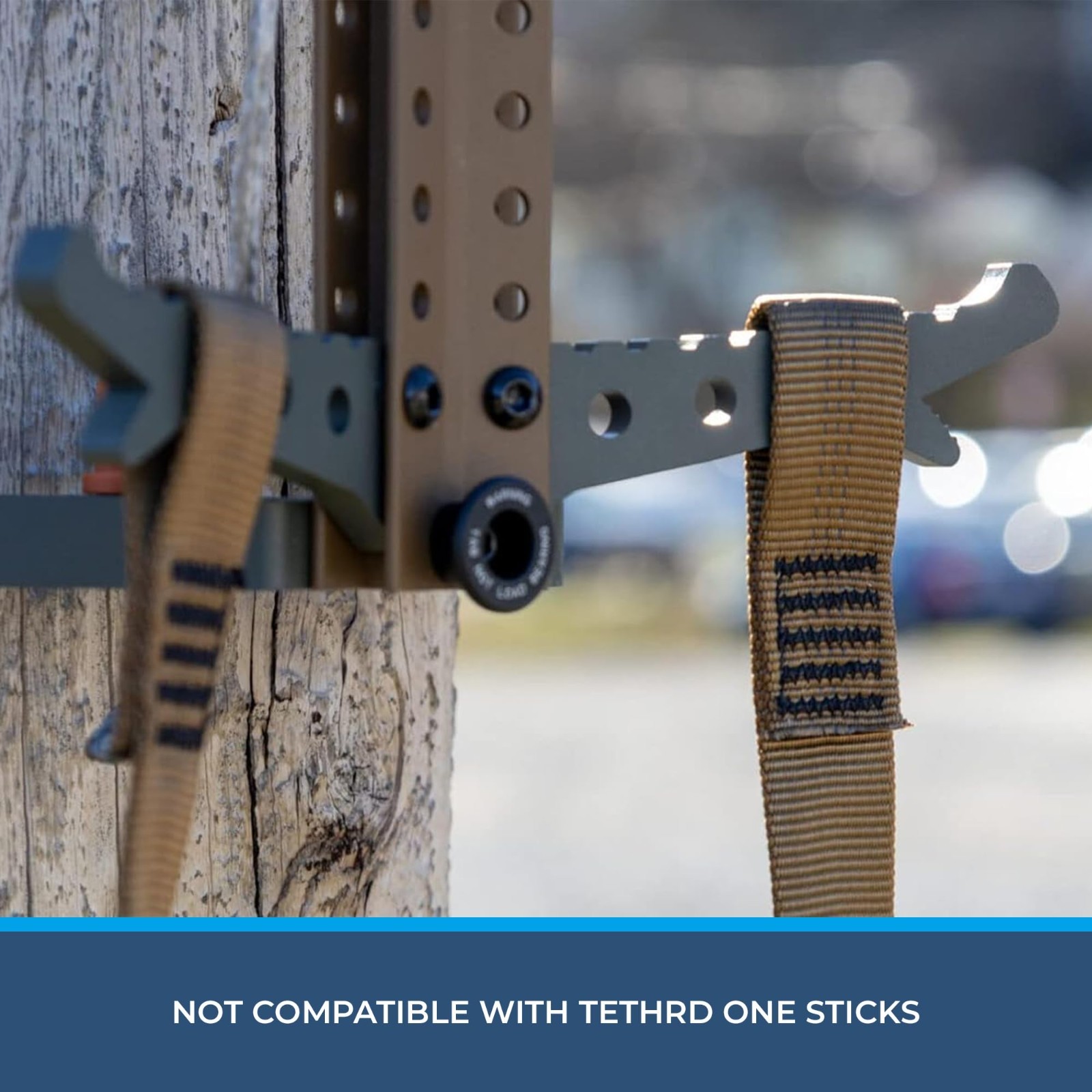 Coyote-colored Step Aider with steel frame and tan straps, USA-made in two pieces, shown against a wooden tree.