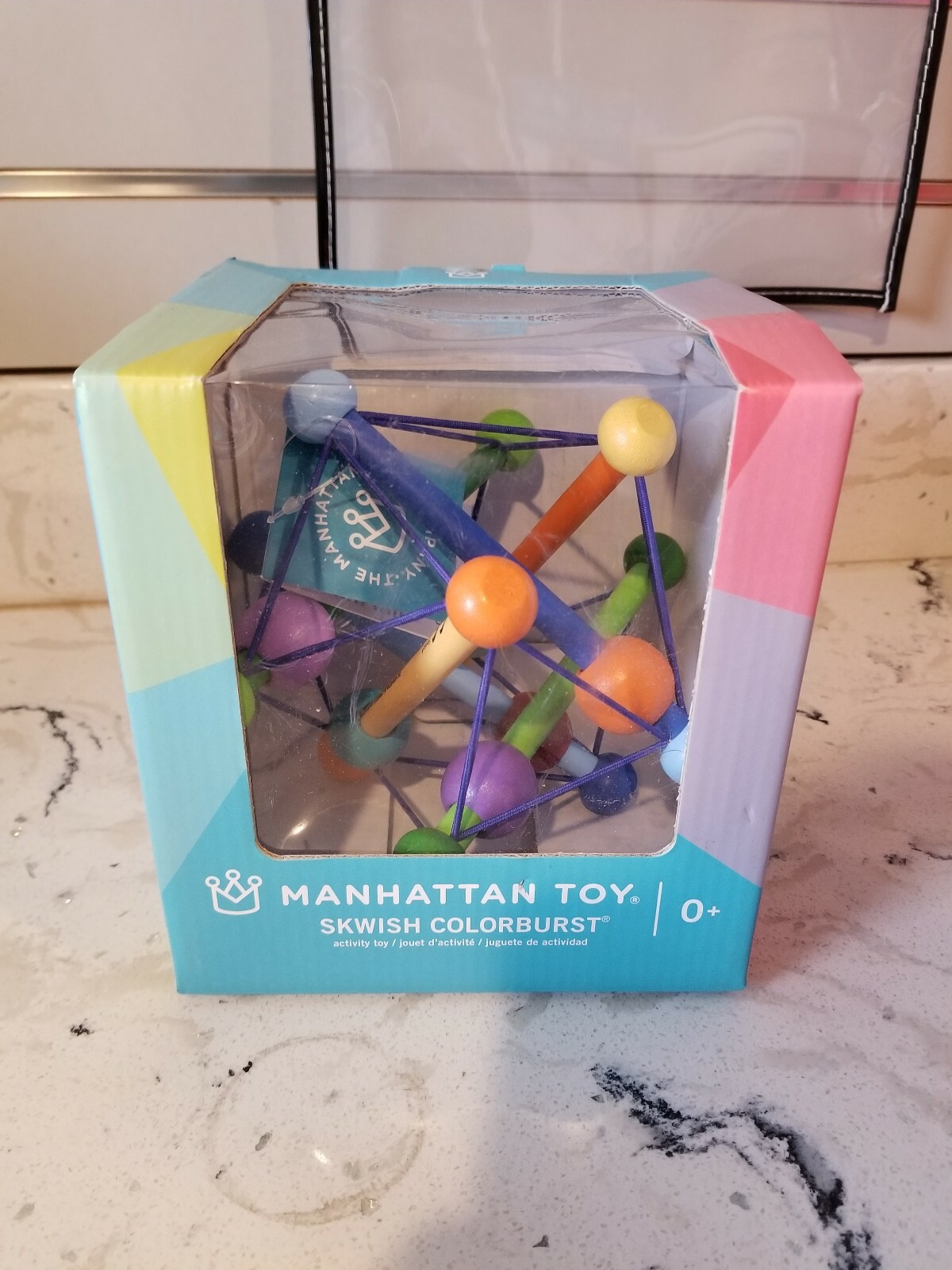 manhattan toy skwish color burst rattle and teether grasping activity toy