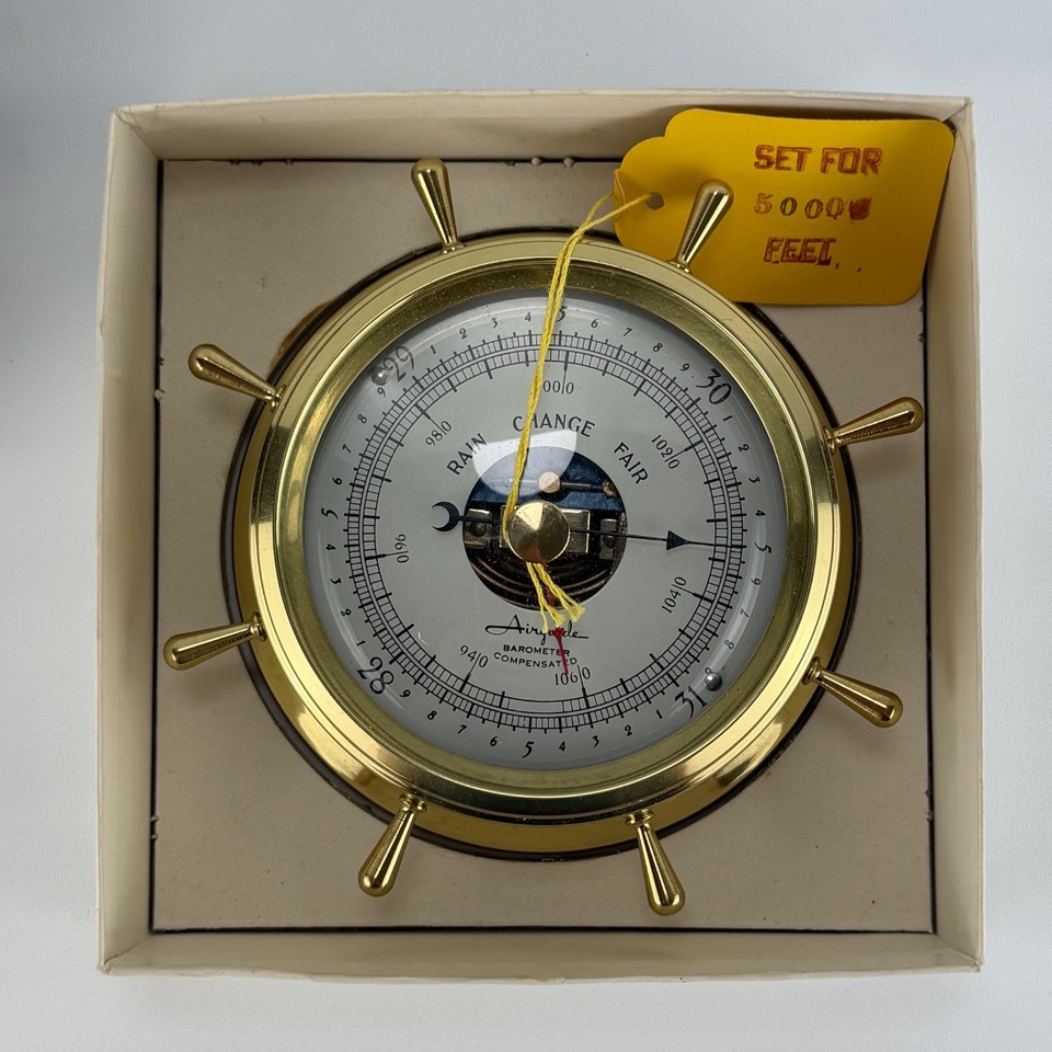 New-old-stock solid brass marine barometer still in its original box with papers and tags — a nautical time capsule that doubles as a stunning desk or shelf piece.