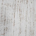 Close-up of white textured plaster with gold metallic cracks and brushstroke pattern on a wooden surface.