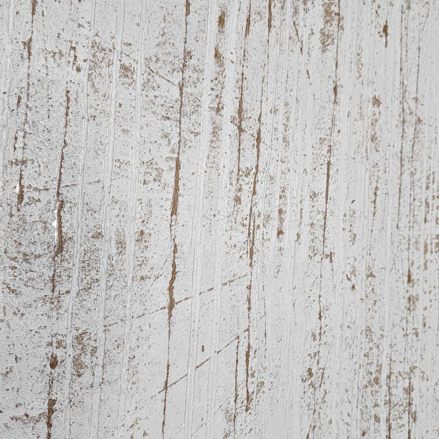 Close-up of white textured plaster with gold metallic cracks and brushstroke pattern on a wooden surface.