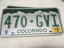 COLORADO LICENSE PLATE EMBOSSED WHITE MOUNTAINS GREEN LETTERS AND BACKGROUND