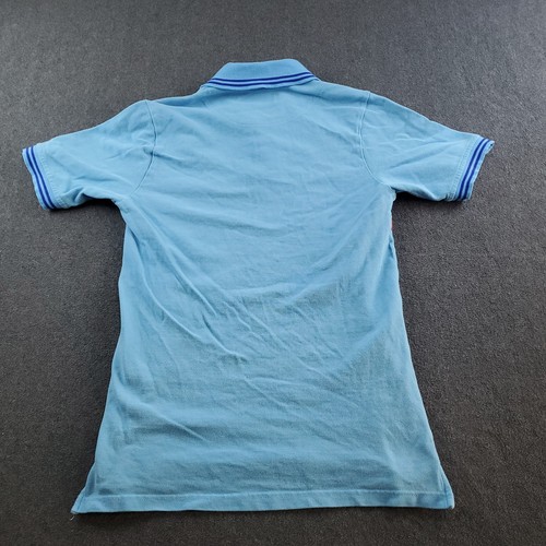 Light blue boys’ polo shirt with white sleeve trim, buttoned at the back, and blue Aston Martin Racing Team logo on chest.