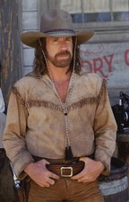 American actor Chuck Norris as he poses in a fringed shirt gun bel- Old Photo