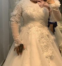 Ivory modest ball gown with illusion neckline, long sleeves, pearls, lace.