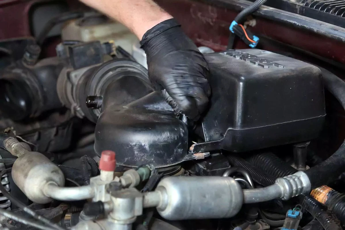 A mechanic reinstalls the air cleaner box.