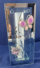 Glasvase hinter Glas -Spiegelrand-Blüte und Schmetterling aufgesetzt