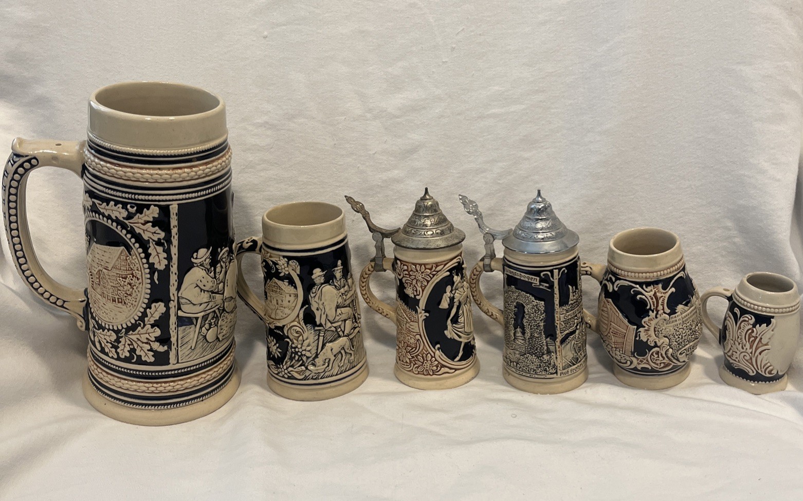 Set of six hand-painted German beer steins with figural designs