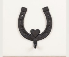 vintage-style cast iron horseshoe wall hooks used for hanging coats, hats, keys