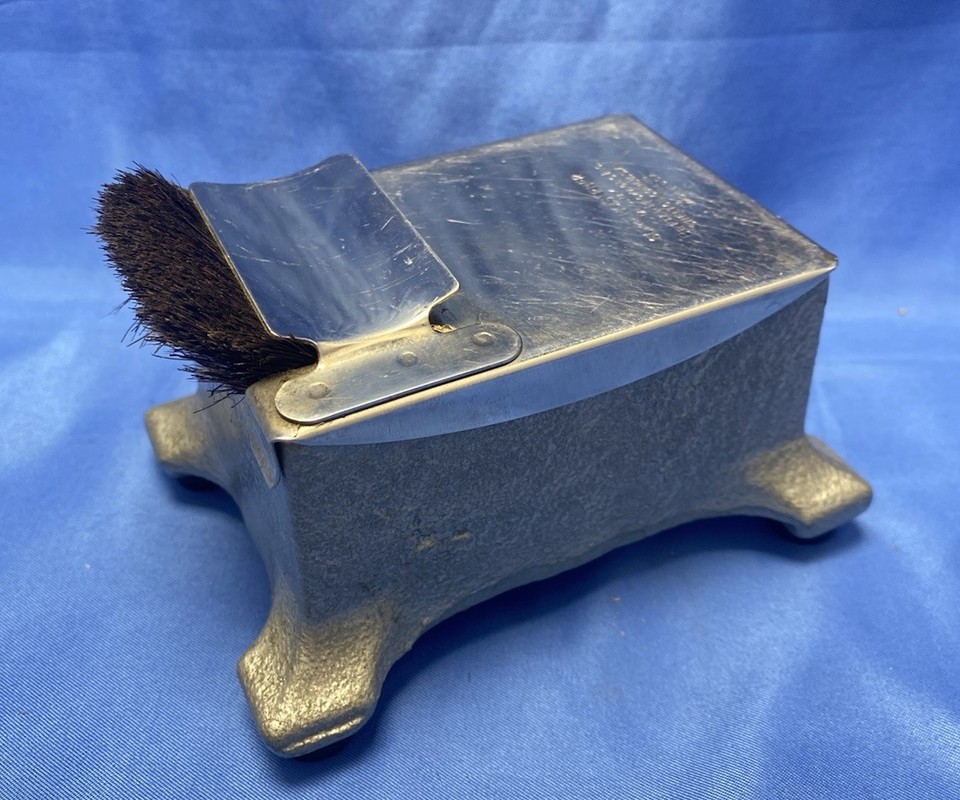 A vintage metal 'Super Moistener' envelope sealer — a beautifully obsolete office tool that looks like a prop from a Mad Men set.