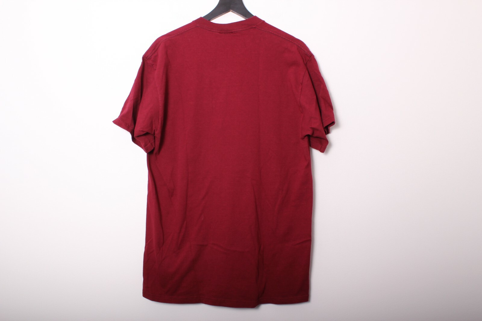 Maroon vintage 1990s T-shirt with crew neck, displayed on black hanger against plain white background.
