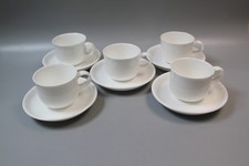 Set of five unbranded white ceramic espresso demitasse cups and saucers