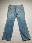 Blue stretch light wash Karen Kane women’s jeans with pink and red stripe details on back pockets, laid flat on gray surface.